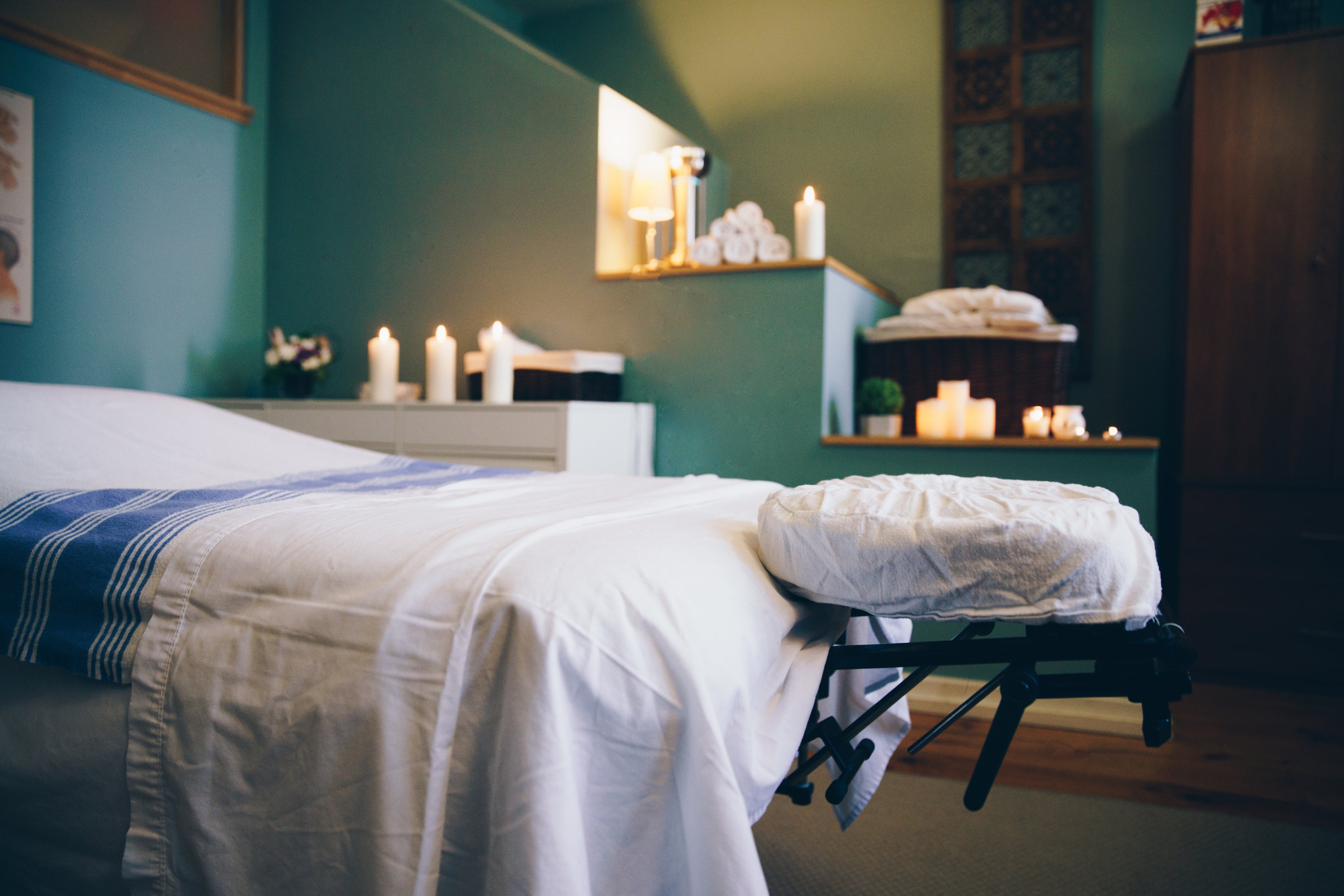 Massage table in a spa, surrounding by cancles and Essential Oil products. Blue & Bear products are available for bulk orders with delightful price breaks.
