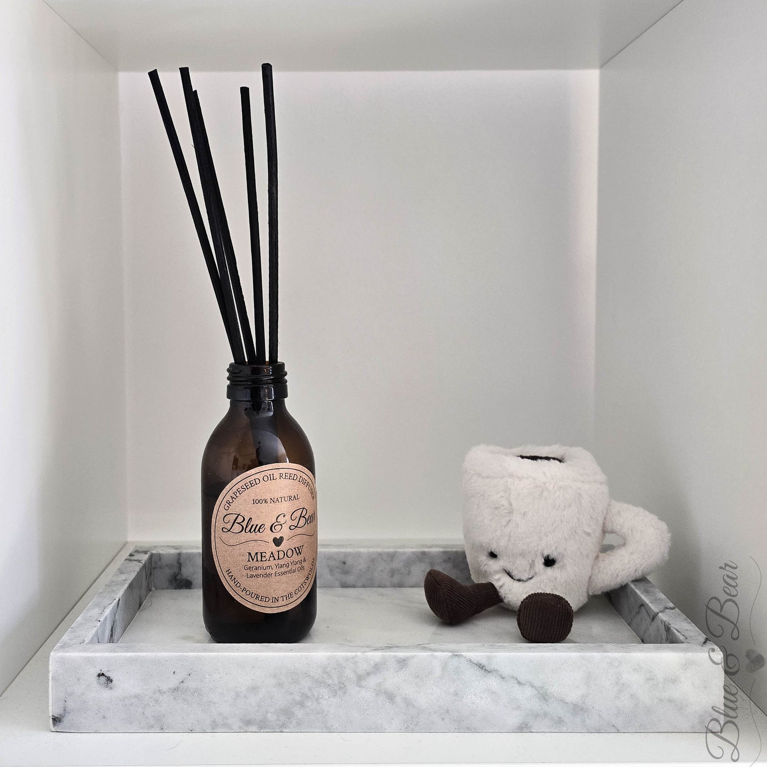 A Blue & Bear MEADOW Reed Diffuser placed on a marble tray.  Perfect for bringing the calming scents of Geranium, Ylang ylang, and Lavender to your home.